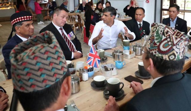 PM Rishi Sunak sitting at a table in a cafe with a group of veterans including Mark Hill, a local community champion for veterans