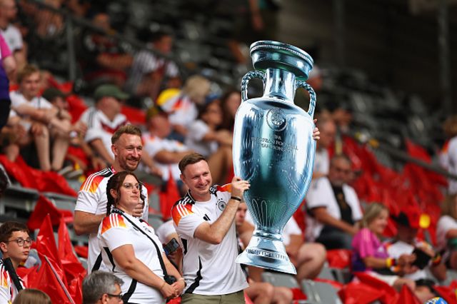 ans of Germany hold up a giant replica cutout of the European Champions trophy