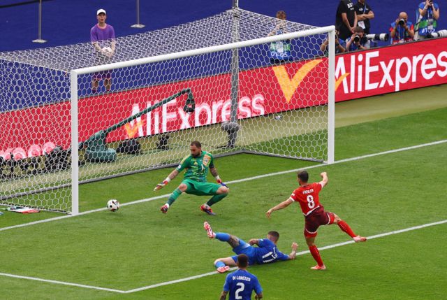 Switzerland's Remo Freuler scores their first goal past Italy's Gianluigi Donnarumma