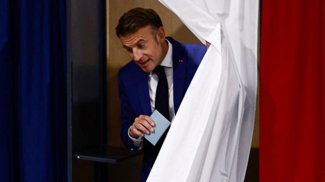 French President Emmanuel Macron leaves a voting booth, as he visits a polling station to vote in the first round of the early French parliamentary elections, in Le Touquet-Paris-Plage, France, on 30 June 2024
