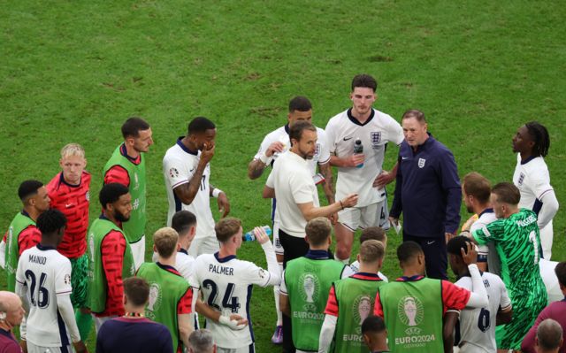 England head coach Gareth Southgate (C) speaks to players as the match goes into extra-time
