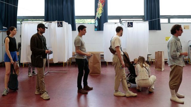 Voters queue in line to cast ballots in the French parliamentary election