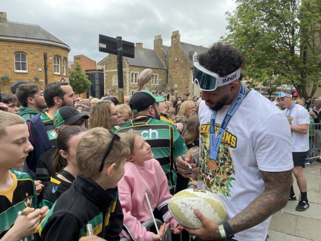 Courtney Lawes signs a fans rugby ball