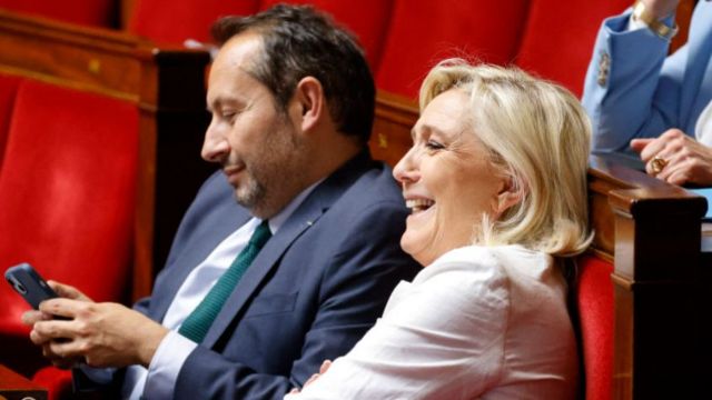President of the 'Rassemblement National' (RN) group at the National Assembly Marine Le Pen (R), flanked by French MP for the 'Rassemblement National' (RN) Sebastien Chenu (L)