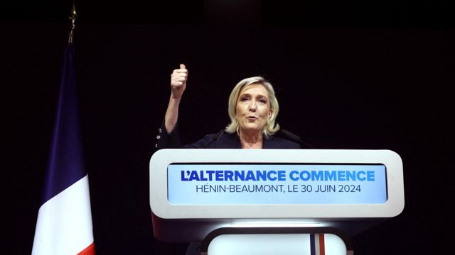 Marine Le Pen speaking at a podium