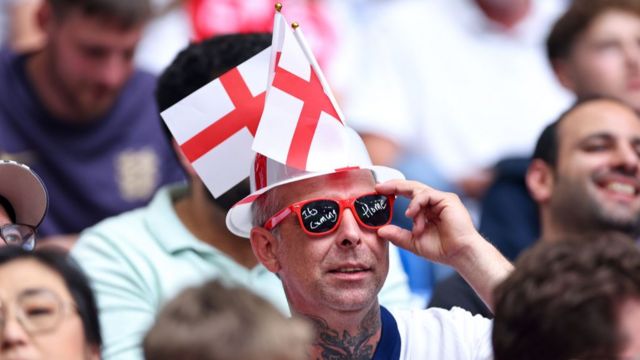 England fan wearing red sunglasses with a plastic England hat during England Euro 2024 game against Slovakia