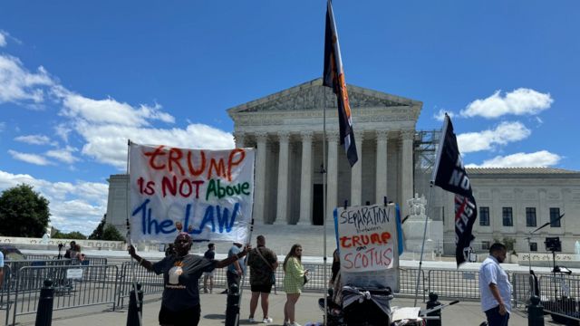 Protesters outside the Supreme Court holding up signs