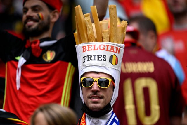 A Belgium fan with a Belgian fries hat on