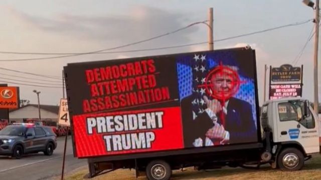 A mobile billboard reading 'Democrats attempted assassination/President Trump'