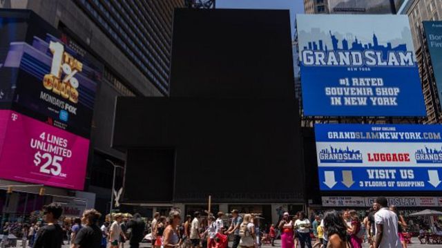 Black screens in New York City's Time Square, along with screens showing an ad for a souvenir shop.