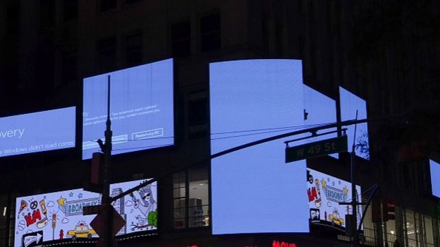 Several billboards displaying a blue screen with error messages.