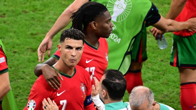 Cristiano Ronaldo is comforted by team-mate Rafael Leao and a member of Portugal's coaching staff