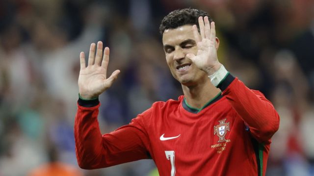 Cristiano Ronaldo holds his hands up in apology to the Portugal fans