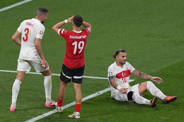Christoph Baumgartner (19) of Austria reacts after missing a goal as Abdulkerim Bardakci of Turkiye sits on the floor