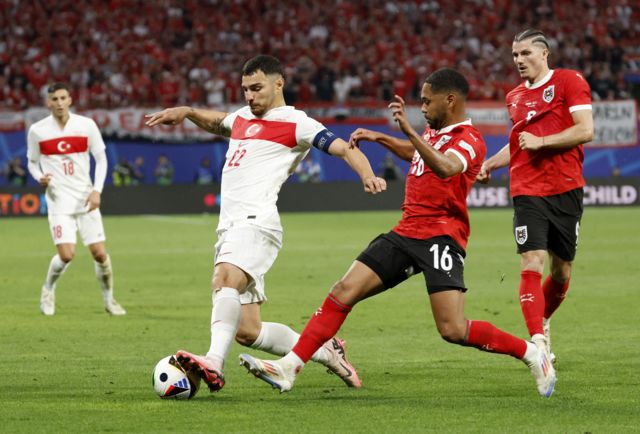 Turkey's Kaan Ayhan in action with Austria's Phillipp Mwene