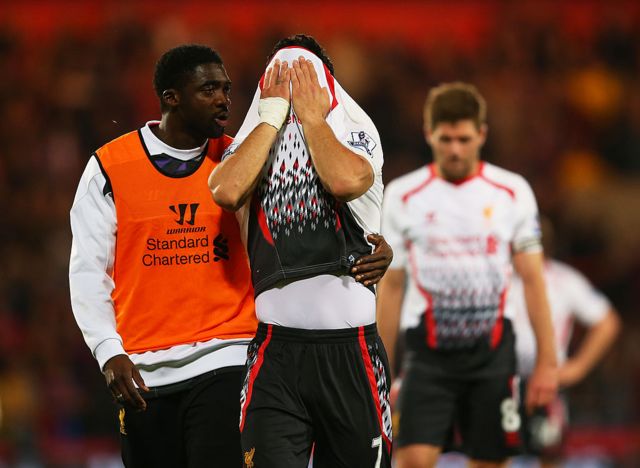 Kolo Toure of Liverpool consoles his dejected teamate Luis Suarez
