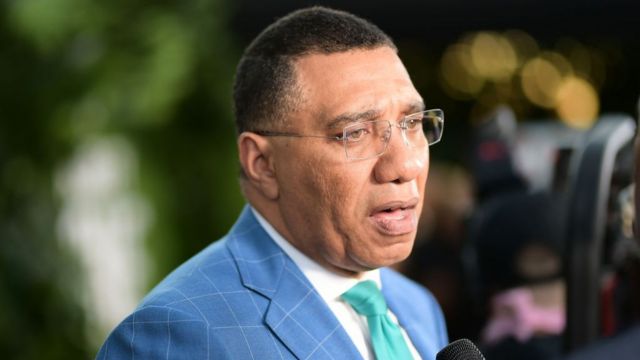 Andrew Holness speaks into a microphone