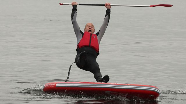 Ed Davey falls theatrically into the water at Windermere