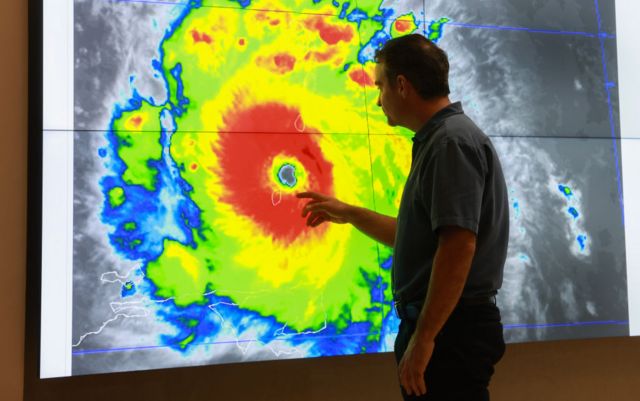 John Cangialosi, Senior Hurricane Specialist at the National Hurricane Center, inspects a satellite image of Hurricane Beryl, the first hurricane of the 2024 season