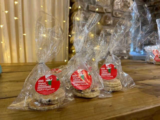 Pile of three bags of Welsh Labour branded cakes on a table