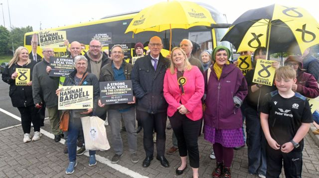 Scottish First Minister and SNP leader John Swinney (centre left) and SNP candidate for Livingston, Hannah Bardell (centre right) with supporters at Livingston Designer Outlet coach park