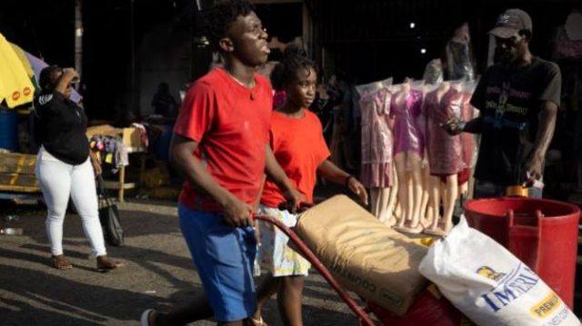People buy supplies in a market in Kingston as they wait for the hurricane