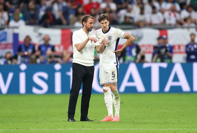 Gareth Southgate, Head Coach of England, speaks with John Stones