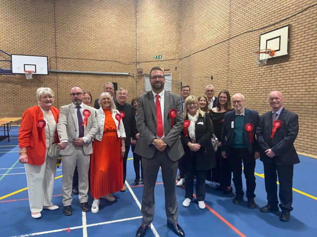 Labour's Mark Ferguson surrounded by rosette-wearing supporters