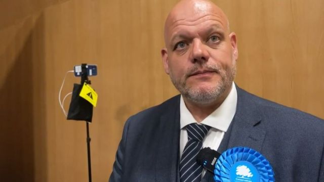 Mark Jenkinson wearing a party rosette