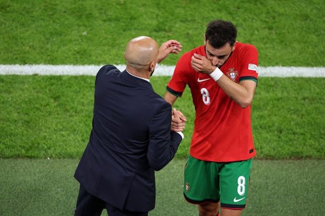 h Roberto Martinez greets Portugal's midfielder Bruno Fernandes as he leaves the pitch