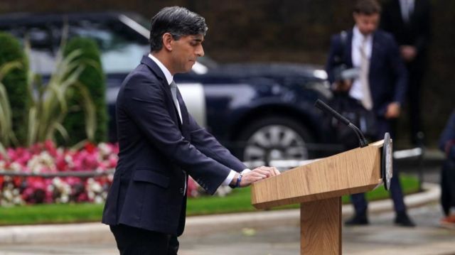 Side on picture of Rishi Sunak standing at a lectern giving a speech