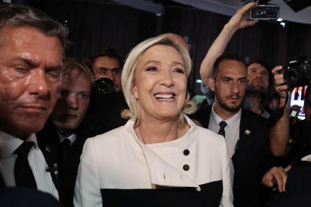 Marine Le Pen surrounded by staff, she is smiling