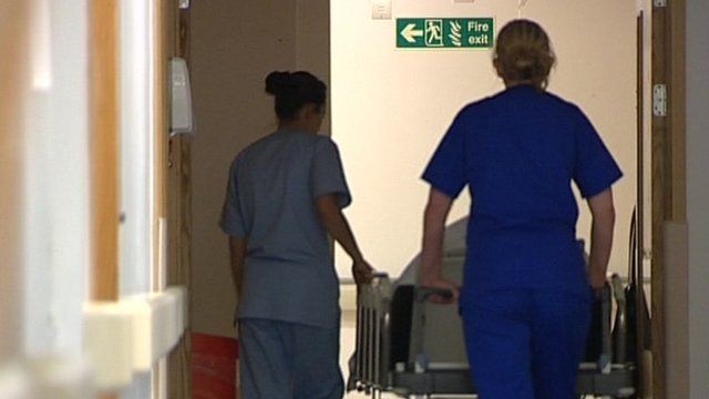 Nurses pushing trolley through hospital corridor