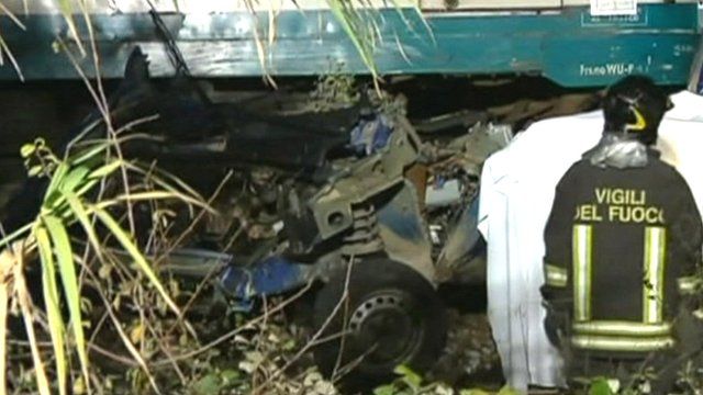Car wreckage trapped under train
