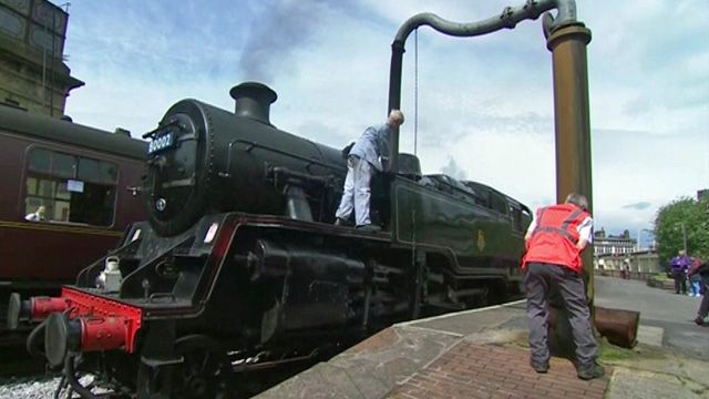 Steam train being refilled with engine water
