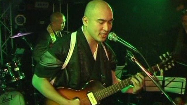 Reverend Kazuhiro Sekino plays guitar