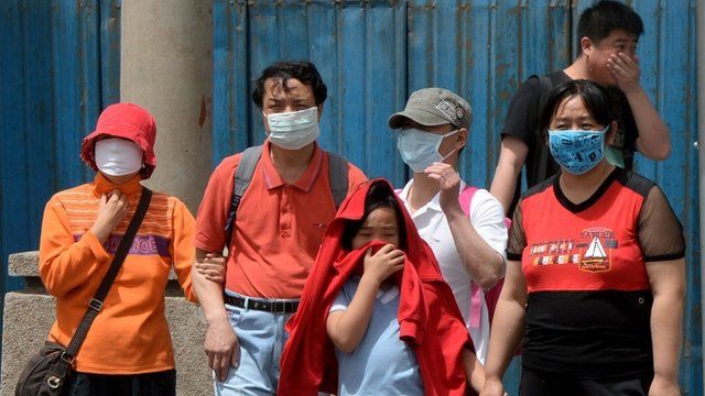 People wear masks to protect against air pollution and dust in Beijing