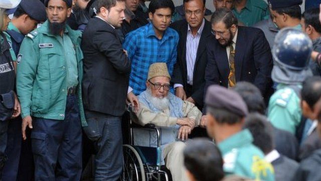 Ghulam Azam is escorted by security personnel and lawyers as he emerges from the Bangladesh International Crimes Tribunal in Dhaka on January 11, 2012