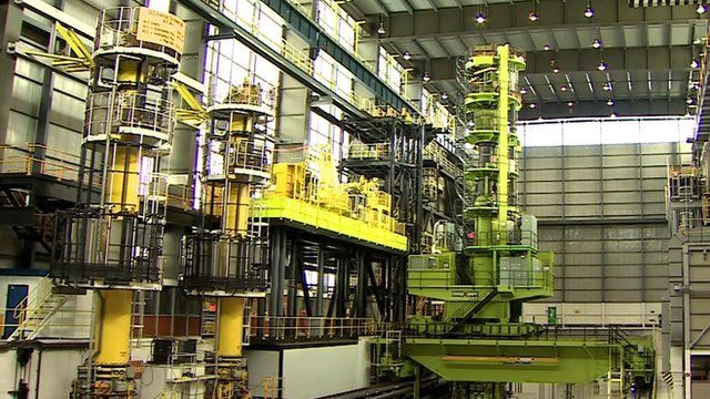Inside a nuclear plant - a green spiral staircase and yellow walkway platform