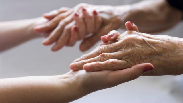 Carer and patient hold hands