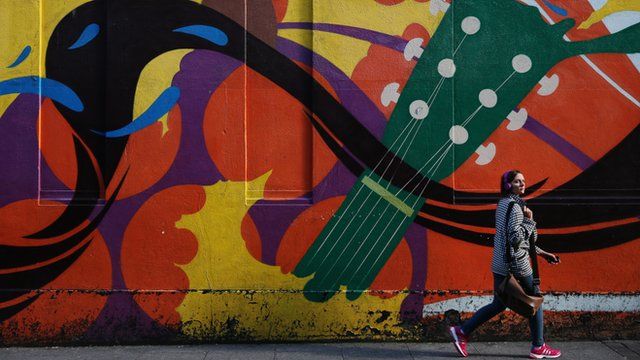 Woman walks past street art in Dublin