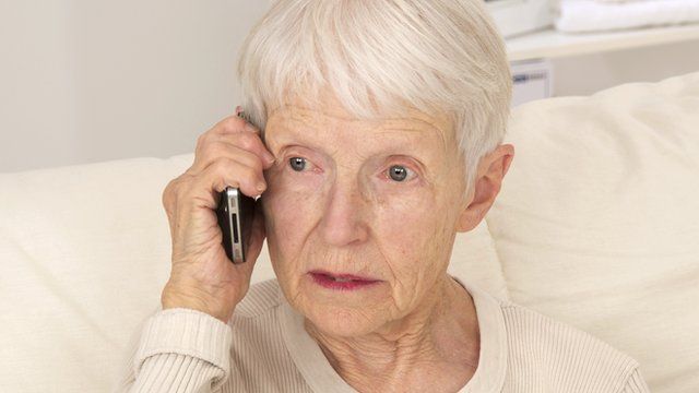 An elderly woman using a phone