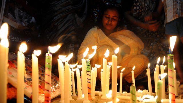 Bangladeshi garment workers and relatives of victims of the Rana Plaza building collapse hold candles during a memorial