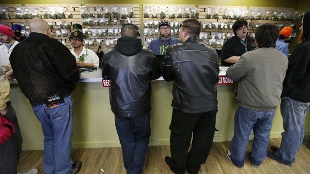 Employees help customers at the crowded sales counter inside Medicine Man marijuana retail store, which opened as a legal recreational retail outlet in Denver on Wednesday Jan. 1,