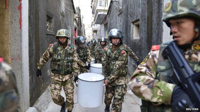 Paramilitary policemen carry seized crystal meth at Boshe village