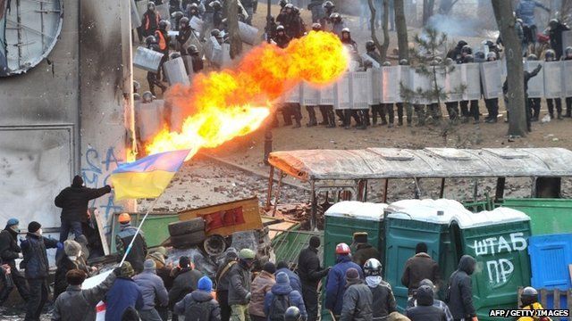 A protester sprays fire in the direction of the riot police during clashes in the centre of Kiev on January 20