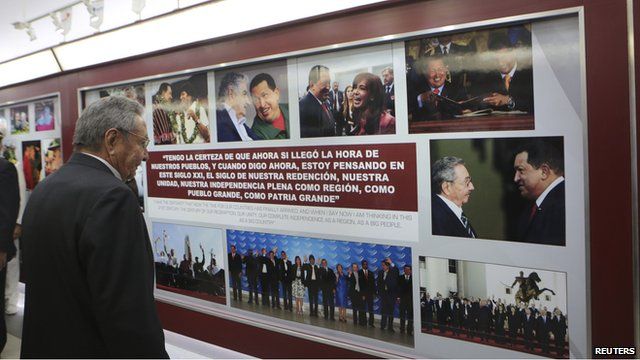 Cuban President Raul Castro looks on at an exhibit dedicated to the late Venezuelan leader Hugo Chavez