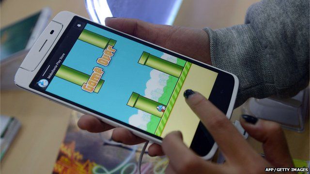 An person plays the game Flappy Bird on a smartphone