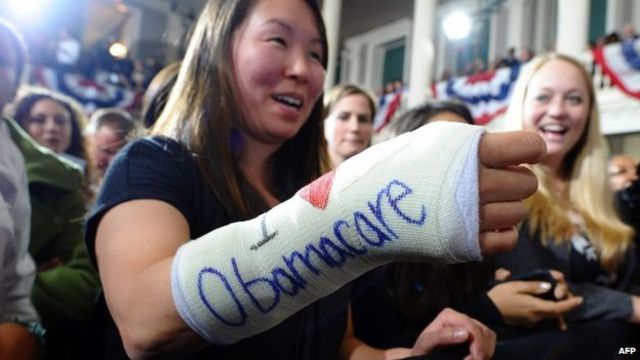 Una mujer con un yeso que dice "yo amo el Obamacare"