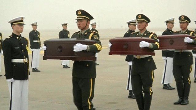 Chinese soldiers holding the coffins